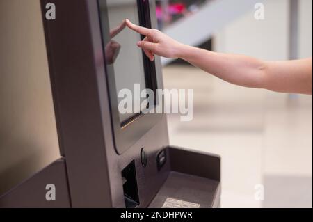 Femme sans visage utilisant l'écran tactile ATM. Banque D'Images