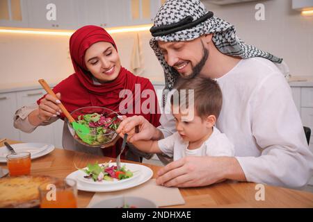 Bonne famille musulmane manger ensemble à table dans la cuisine Banque D'Images