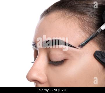 Esthéticienne appliquant la teinte pendant la procédure de correction des sourcils sur fond blanc, gros plan Banque D'Images