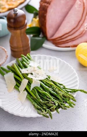 Asperges cuites sur une assiette recouverte de parmesan Banque D'Images