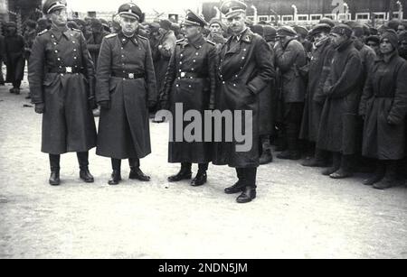 Membres de l'unité de gardes du camp de Totenkopf au camp de concentration de Mauthausen. Les prisonniers peuvent être vus alignés en arrière-plan. L'unité des gardes de Totenkopf était une unité distincte au sein de la SS et était responsable de la gestion des camps de concentration et d'extermination. Ils se distinguent par l'emblème de la tête de la mort sur leur revers. La division de 3rd SS Panzer portait le nom de Totenkopf mais était une unité de combat qui n'était pas impliquée dans l'administration des camps. Par Bundesarchiv, Bild 183-78612-0010 / CC-BY-sa 3,0, CC BY-sa 3,0 de, https://commons.wikimedia.org/w/index.php?curid=5431255 Banque D'Images