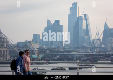 Londres, Royaume-Uni. 15th févr. 2023. Les navetteurs traversent le pont de Waterloo avec la ville de Londres, le quartier financier de la capitale en vue sur 15 février 2023 à Londres, au Royaume-Uni. L'inflation de l'IPC a diminué aujourd'hui à 10,1%, plus rapidement que prévu selon l'Office for National Statistics, même si elle reste proche d'un niveau élevé de 40 ans. Crédit : SOPA Images Limited/Alamy Live News Banque D'Images