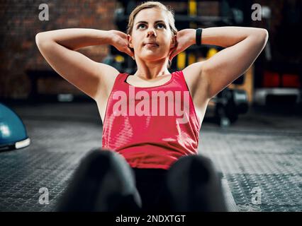 Force de base. une jeune athlète féminine attrayante faisant des séances dans la salle de gym. Banque D'Images