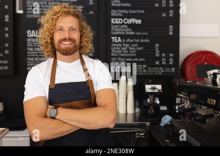 Portrait d'un barista de race blanche heureux avec les bras croisés dans un café. Café, temps libre et concept de ville. Banque D'Images