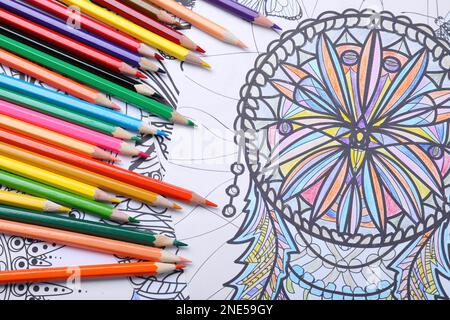 Crayons sur les pages de coloriage antistress, vue de dessus Banque D'Images