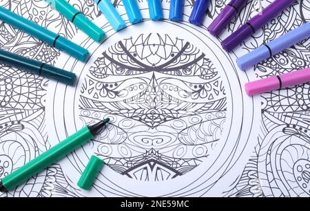 Feutres sur la page de coloriage antistress, vue de dessus Banque D'Images