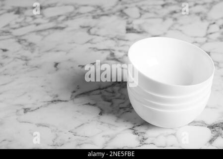 Pile de bols en céramique vides sur une table en marbre blanc, espace pour le texte Banque D'Images