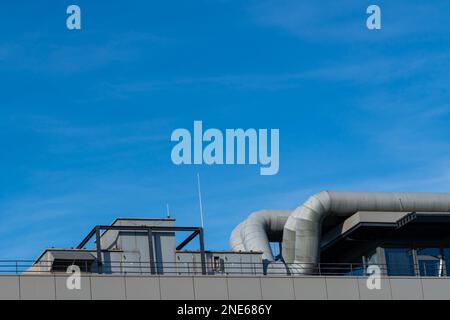 Tuyaux de ventilation sur le toit d'un bâtiment sous un ciel bleu. Banque D'Images