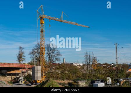 Chantier de construction avec une grande grue de construction jaune. Ciel bleu avec nuages clairs. Banque D'Images
