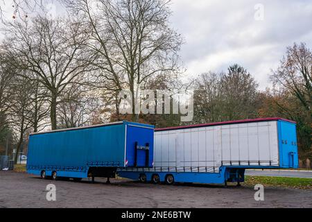 Deux remorques de gros camions bleu et blanc dans le parking. Banque D'Images