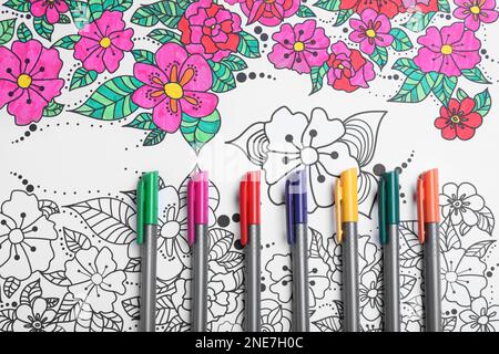 Feutres sur la page de coloriage antistress, vue de dessus Banque D'Images