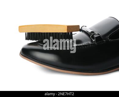 Chaussure et brosse noires sur fond blanc, gros plan. Entretien des chaussures Banque D'Images