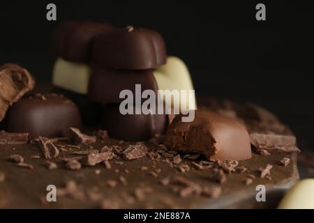 Belles bonbons au chocolat en forme de coeur sur panneau en bois, gros plan Banque D'Images