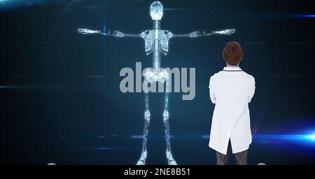 Composition d'un médecin de sexe masculin utilisant un écran virtuel avec un modèle de squelette Banque D'Images