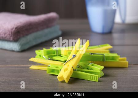 Pile de épingles à linge en plastique colorées sur une table en bois Banque D'Images