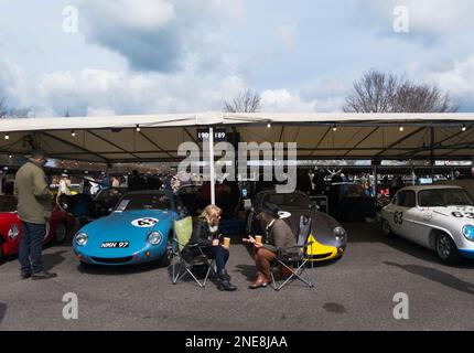 Deux dames discutant à côté de voitures en compétition à la Weslake Cup, 79th Members Meeting, circuit automobile de Goodwood, Chichester, West Sussex, Royaume-Uni Banque D'Images