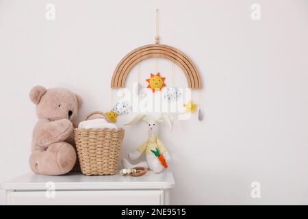 Commodes avec jouets et couches près du mur lumineux dans la chambre de bébé. Design intérieur Banque D'Images