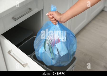 Femme prenant le sac à ordures hors de la poubelle à la maison, gros plan Banque D'Images