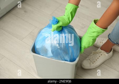 Femme prenant le sac à ordures hors de la poubelle à la maison, gros plan Banque D'Images