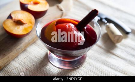 Pêche cuite dans du vin rouge à la cannelle. Recette traditionnelle espagnole. Banque D'Images