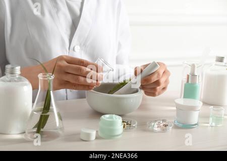 Scientifique faisant des produits cosmétiques à la table en laboratoire, gros plan Banque D'Images