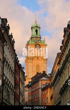 Tour de l'horloge de l'église Saint-Nicolas, derrière une rue historique de bâtiments colorés dans la vieille ville de Gamla Stan, Stockholm, Suède. Banque D'Images