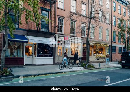 New York, Etats-Unis - 21 novembre 2022: Rangée de magasins dans une rue dans West Village, un quartier charmant de Manhattan célèbre pour ses magasins et restaurants, les femmes Banque D'Images