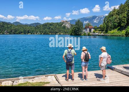 Grands-parents avec petite-fille qui a vue sur le lac Bled, par une journée ensoleillée d'été dans le nord de la Slovénie, destination touristique populaire de l'excursion d'une journée. Banque D'Images