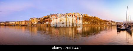 Vue panoramique sur le bar-restaurant flottant grain Barge avec des rangées de maisons colorées derrière, vue depuis la marina, au lever du soleil. ROYAUME-UNI Banque D'Images