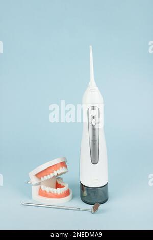 Fausses dents avec un irrigateur à cavité buccale qui nettoie les dents et les mâchoires. Instruments de dentisterie et concept de contrôle de l'hygiéniste dentaire Banque D'Images