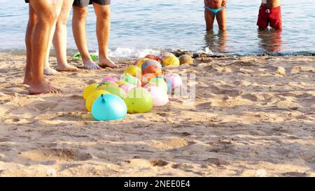 sur la plage, sur le sable sont des ballons remplis d'eau au lieu de l'air. les gens se reposent sur des jeux amusants sur la plage. Photo de haute qualité Banque D'Images