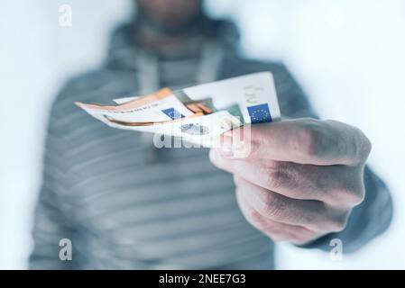 mi-section de l'homme tenant des billets dans sa main la remettant à quelqu'un, payant avec le concept de trésorerie Banque D'Images