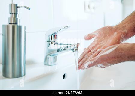 gros plan de la personne se lavant soigneusement les mains à l'évier de salle de bains avec du savon et de l'eau chaude, mesure d'hygiène pendant la pandémie de covid-19 de coronavirus pour éviter Banque D'Images