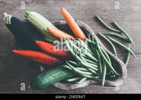 Directement au-dessus de coup de bol en bois remplis de matières légumes frais de saison sur table en bois rustique Banque D'Images