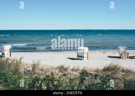 chaises de plage à baldaquin sur une plage de sable, au bord de la mer baltique et du ciel bleu clair Banque D'Images