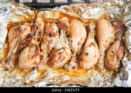 Pilons de poulet cuits sans peau. Cuit dans du papier d'aluminium avec des oignons et des assaisonnements. Cuisine maison. Aliments sains, cuits sans huile ni sel. Banque D'Images