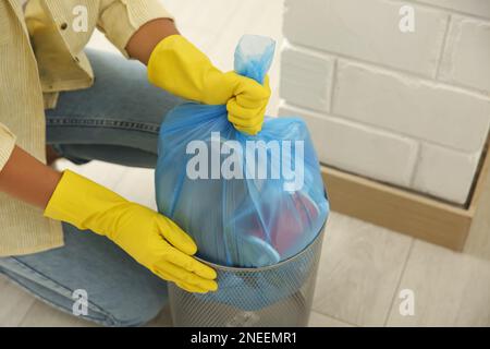 Femme prenant le sac à ordures hors de la poubelle à la maison, gros plan Banque D'Images