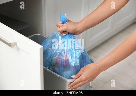 Femme prenant le sac à ordures hors de la poubelle à la maison, gros plan Banque D'Images