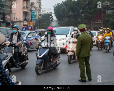 Un officier de l'armée en uniforme dirige un trafic important à Hanoi, Vietnam. Banque D'Images