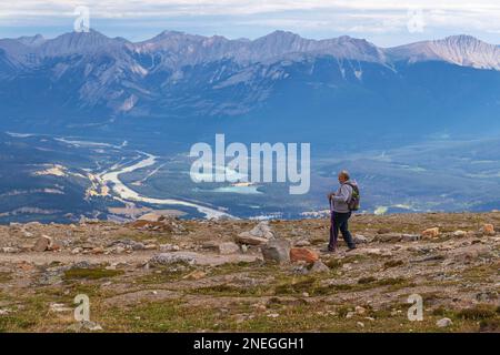 Homme âgé avec des bâtons de marche faisant de la randonnée sur le pic de Whistlers Mountain dans le parc national Jasper, Canada. Banque D'Images