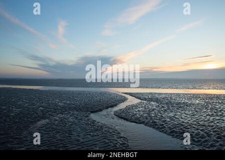 Un chenal à marée basse dans l’estuaire près de Jenny Brown’s point, près du village de Silverdale. La baie de Morecambe est célèbre pour ses couchers de soleil, le déplacement des sables a Banque D'Images