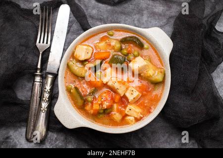 Délicieux calamar de ragoût avec des légumes dans un bol à l'obscurité Banque D'Images