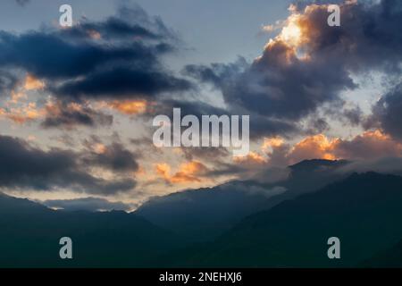 Des nuages colorés au-dessus de la chaîne de montagnes de l'Himalaya après que le soleil s'est installé au-delà des sommets de montagne. Après le coucher du soleil image de stock nature , tourné à Okhrey, Sikkim Banque D'Images