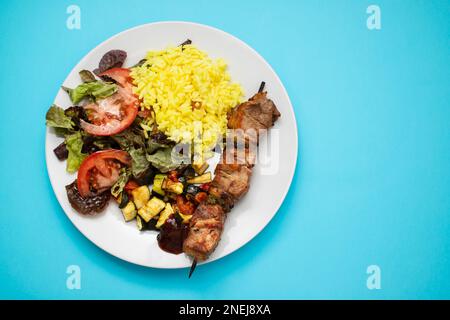 Viande grillée sur bâton, légumes, salade et riz bouilli sur l'assiette Banque D'Images