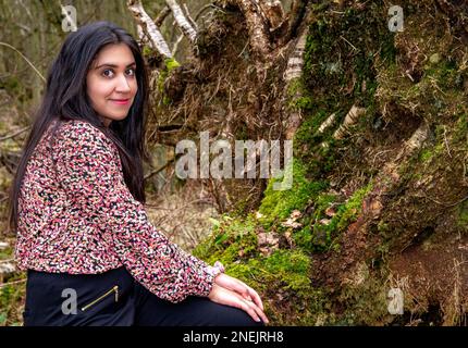 Une femme belle et à la mode passe la journée à prendre sa photo dans les bois du Clatto Country Park de Dundee, en Écosse, au Royaume-Uni Banque D'Images