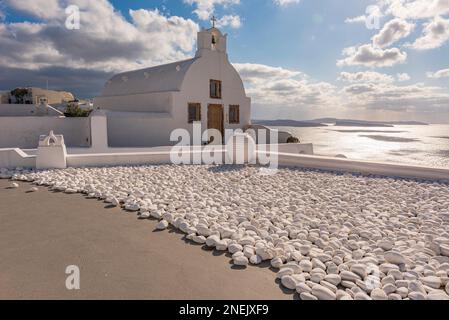 Vue panoramique sur la caldeira depuis une chapelle typique blanchie à la chaux dans le village d'Oia, Santorin Banque D'Images