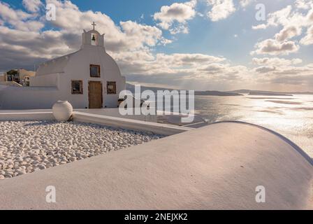 Vue panoramique sur la caldeira depuis une chapelle typique blanchie à la chaux dans le village d'Oia, Santorin Banque D'Images