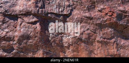 Surface grossière d'une roche rouge-brun en gros plan Banque D'Images