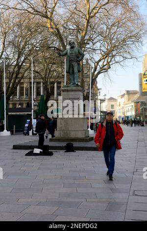 La Hayes, Cardiff. Statue de John Bachelor, bucker et passant par. Février 2023. Hiver. cym Banque D'Images