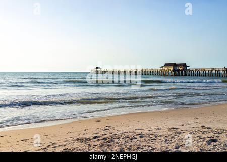 Naples, Floride célèbre jetée au coucher du soleil sur la côte du golfe du Mexique comme jetée en bois avec des gens avant que l'ouragan Ian l'ait détruit avec des vagues d'eau et du bleu Banque D'Images